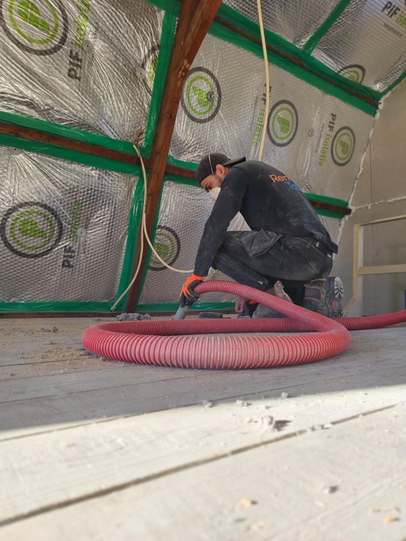 Dakisolatie met ingeblazen isolatiemateriaal op een hellend dak