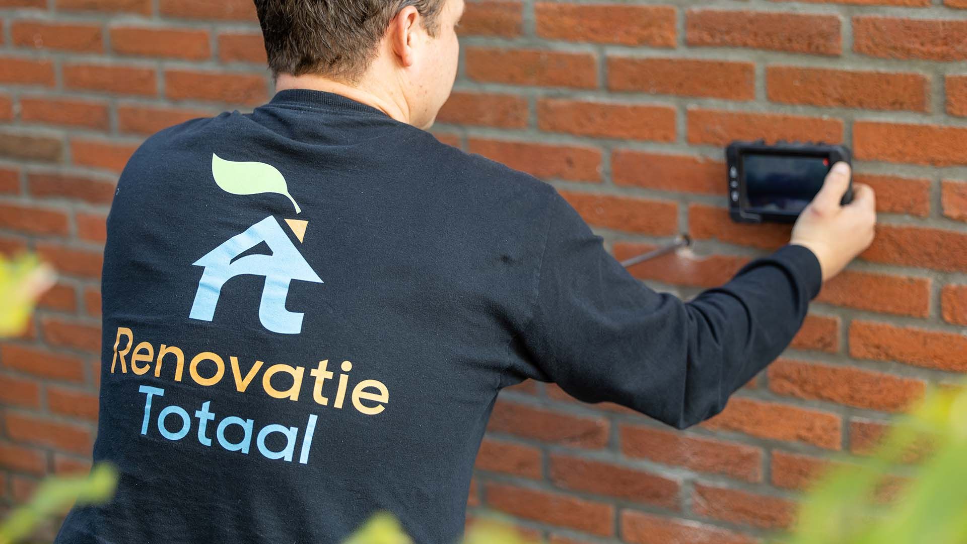 Adviseur onderzoekt de spouwmuur van een woning in Haarlem