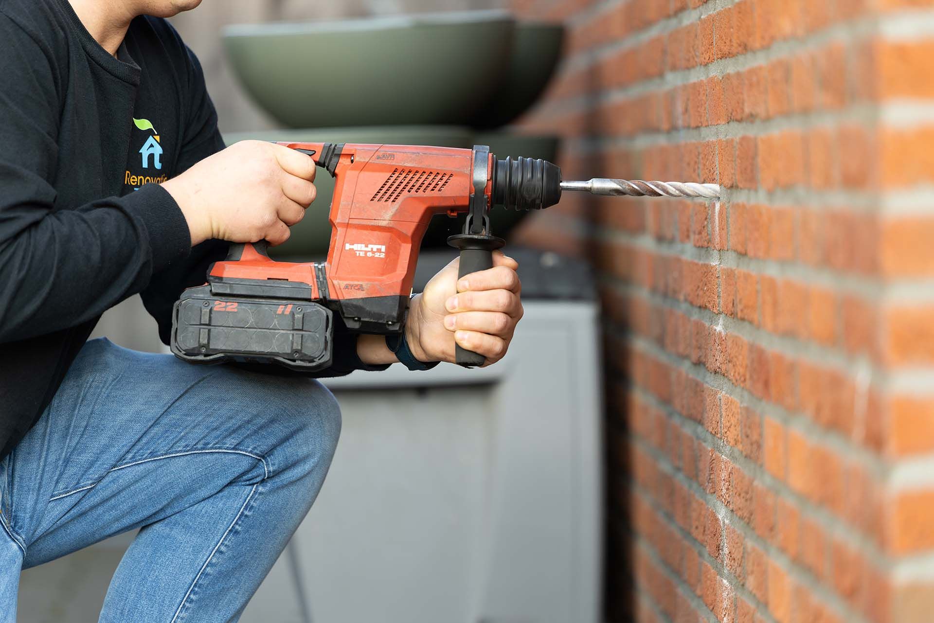 Monteur blaast isolatie in een spouwmuur van een woning in Haarlem