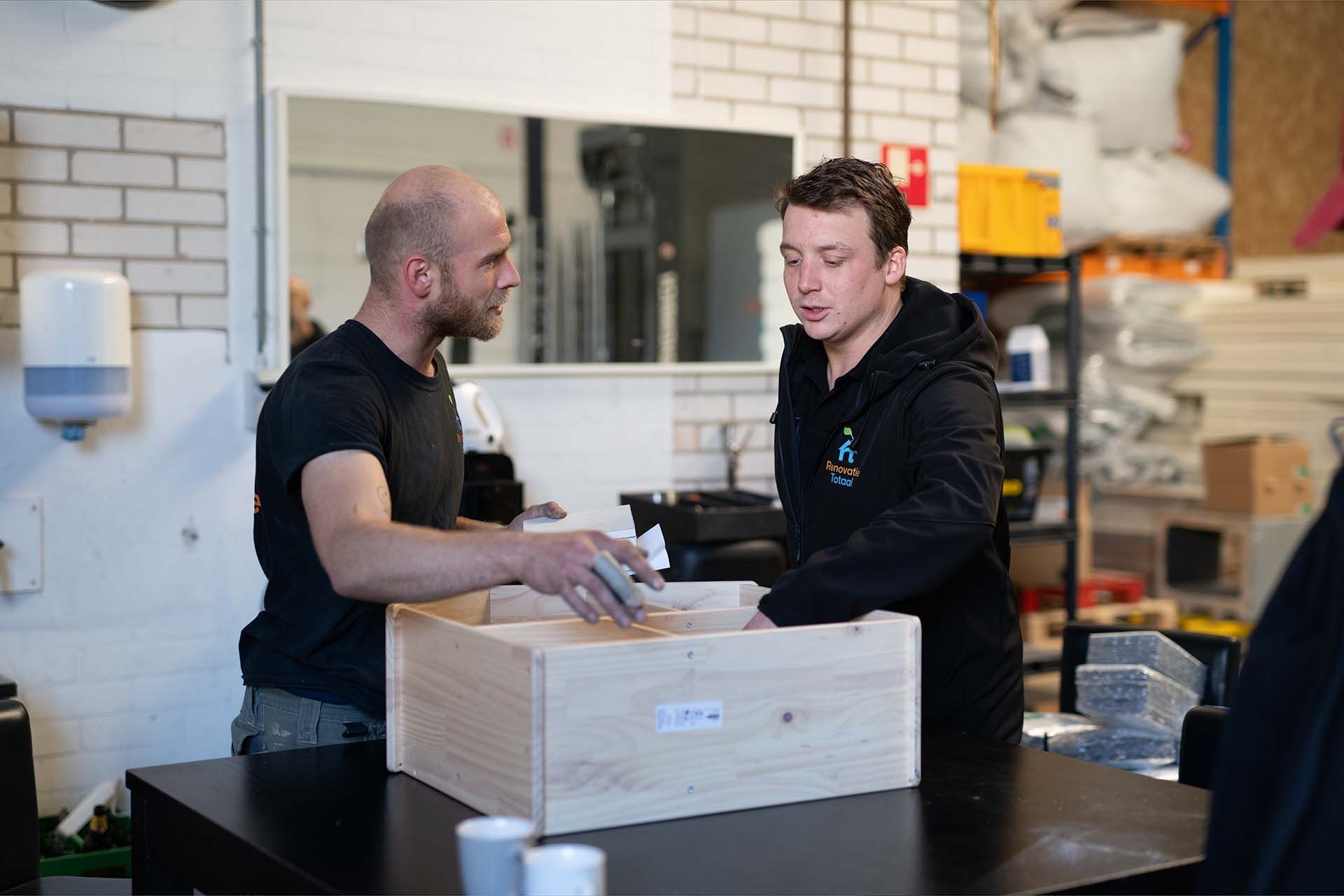 Twee collega's van Isolatiebedrijf Haarlem overleggen over een isolatieklus